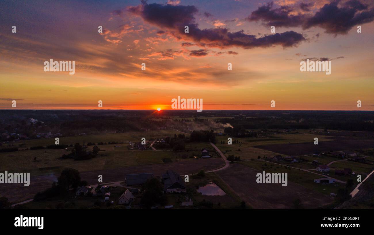 Drohnenaufnahme der Landseite unter Sonnenuntergang mit Tal und Wald Stockfoto