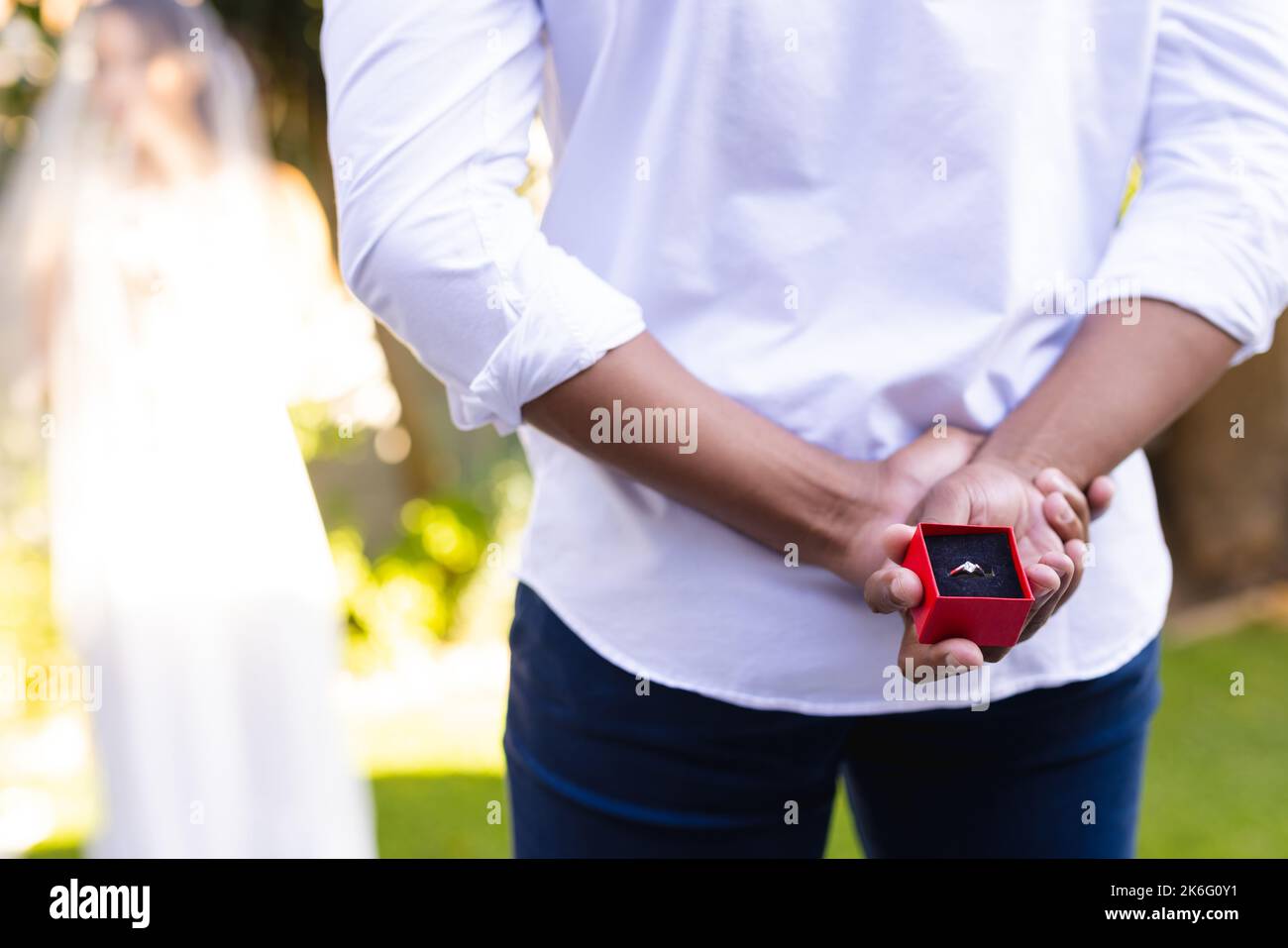 Mittelteil eines afroamerikanischen Mannes, der am Hochzeitstag den Ring hält Stockfoto