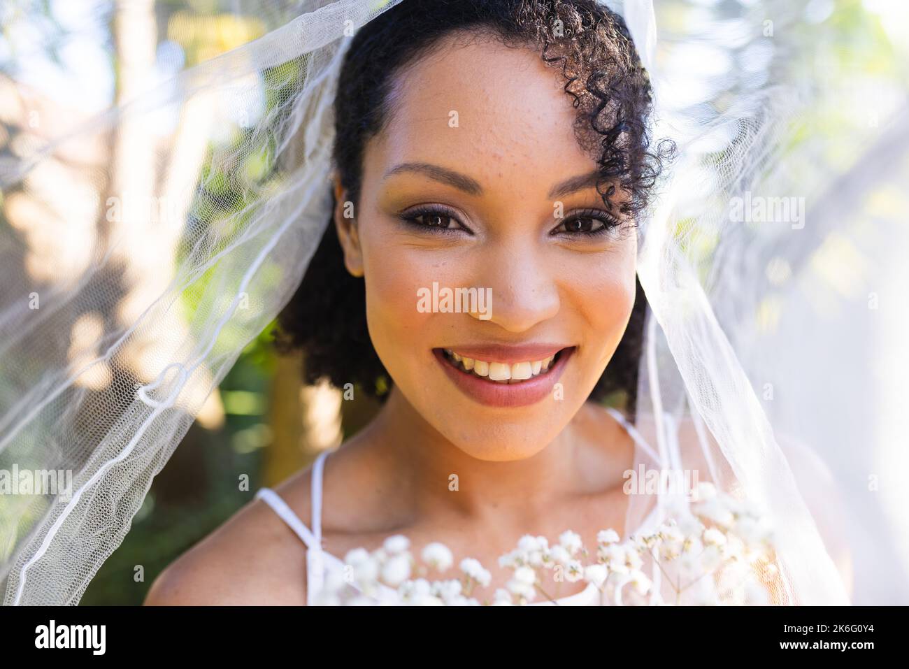 Porträt einer glücklichen afroamerikanischen Frau, die am Hochzeitstag Hochzeitskleid und Schleier trägt Stockfoto