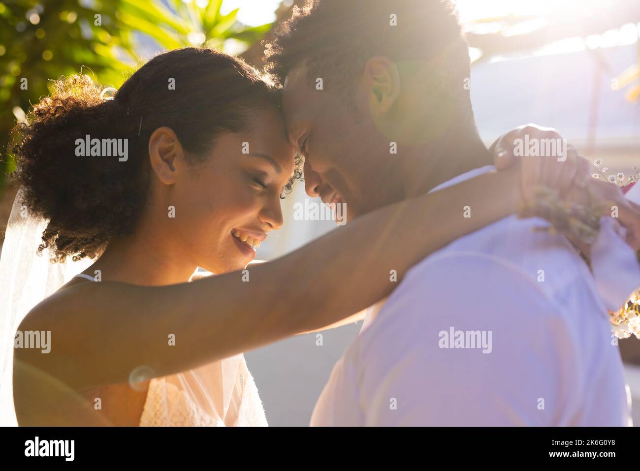 Glückliches afroamerikanisches Paar heiratet, umarmt sich am Hochzeitstag Stockfoto