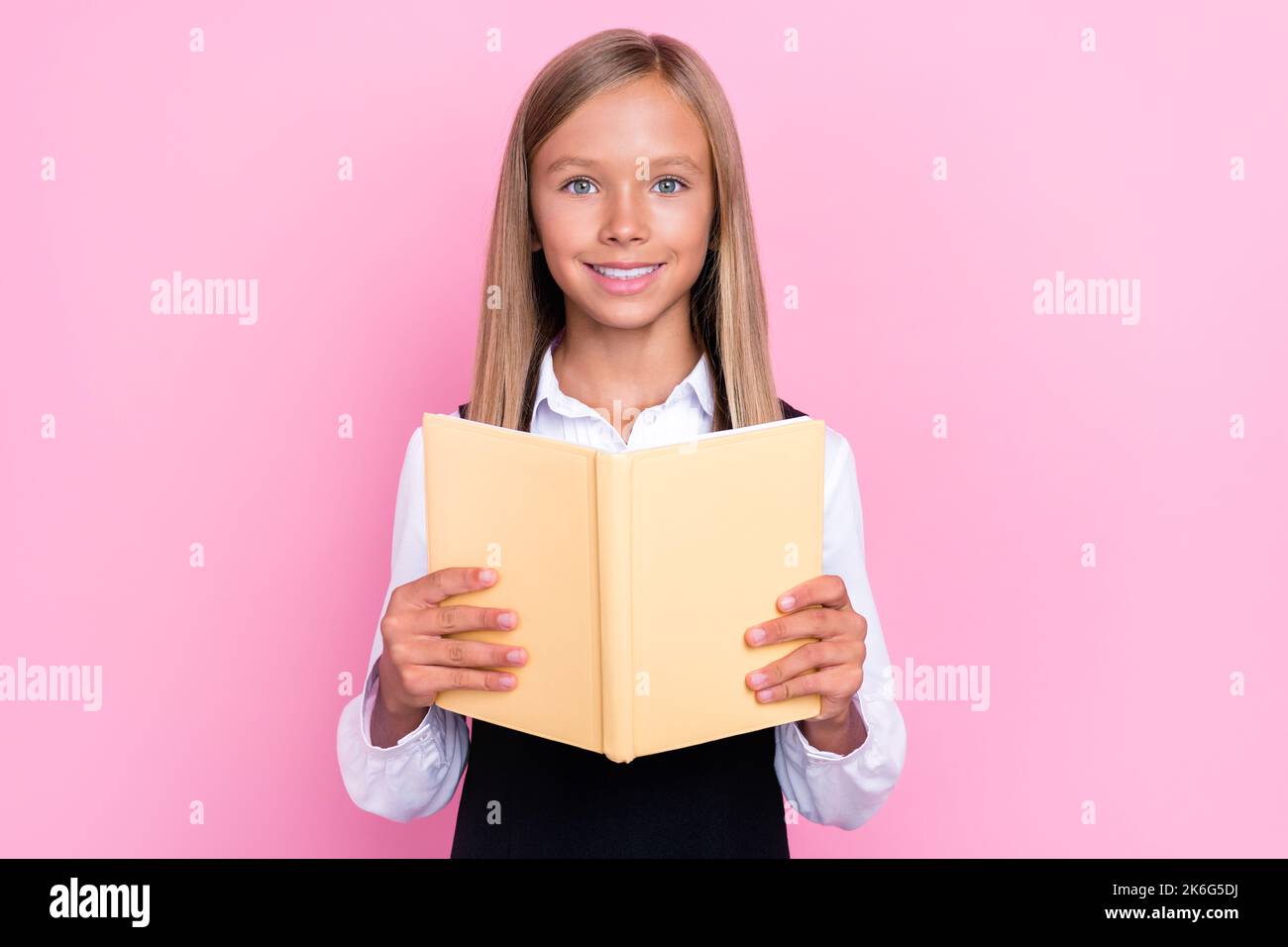 Foto von intelligenten Schüler lesen Hausaufgaben Roman im Klassenzimmer isoliert auf pastellfarbenem Hintergrund Stockfoto