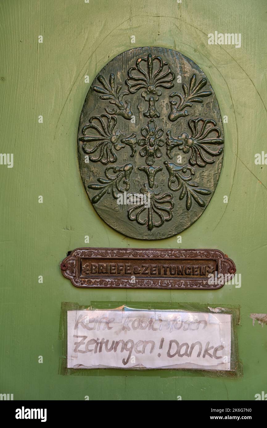 Ovale Schnitzerei und Türschlitz mit der Aufschrift „Letters & Newspapers“ und der Aufschrift „No free Newspapers“ auf dem Türblatt einer historischen Eingangstür. Stockfoto