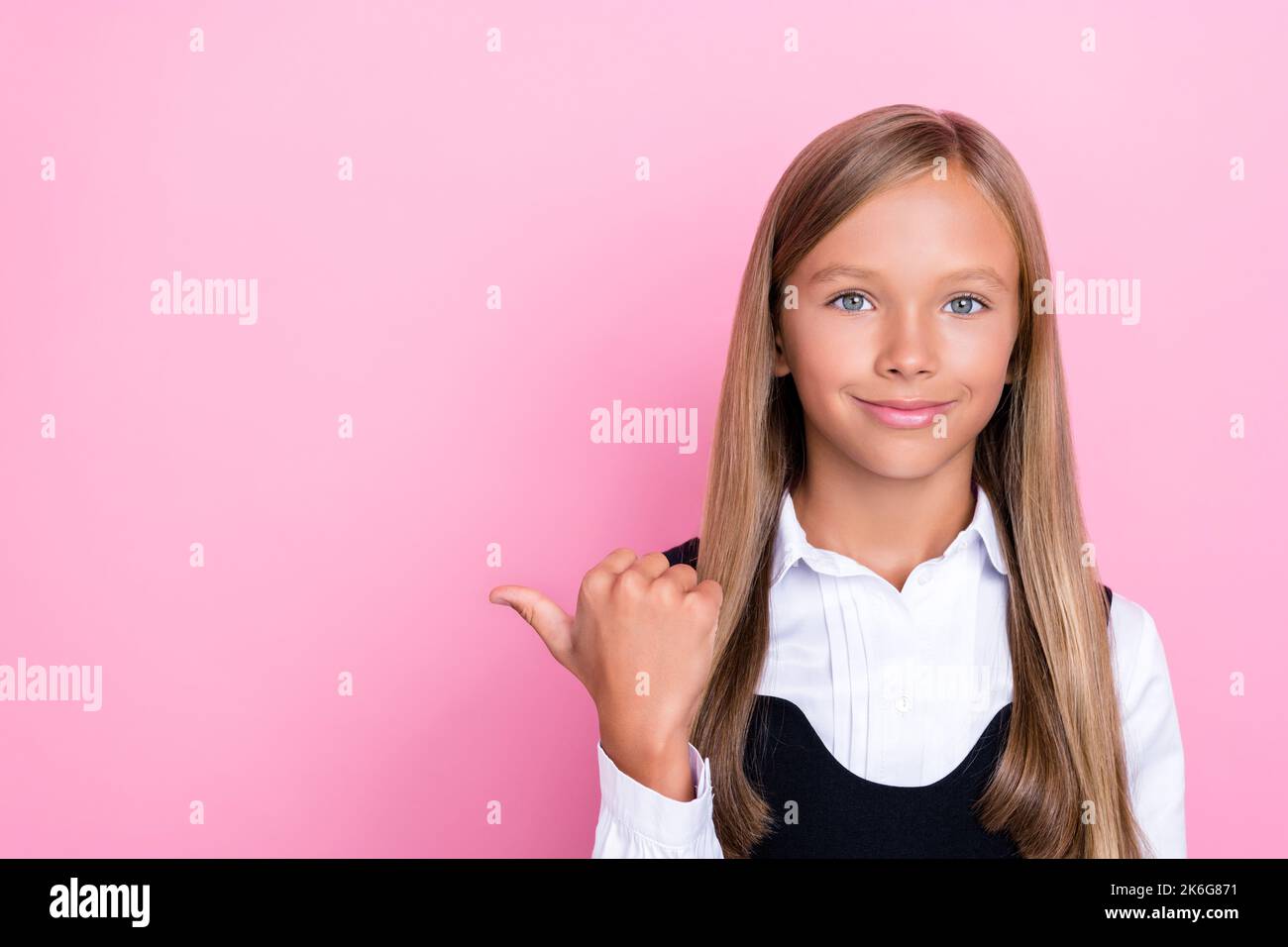 Foto von schönen smart fröhlich Schulmädchen mit geraden Frisur tragen Schuluniform Regie leeren Raum isoliert auf rosa Hintergrund Stockfoto