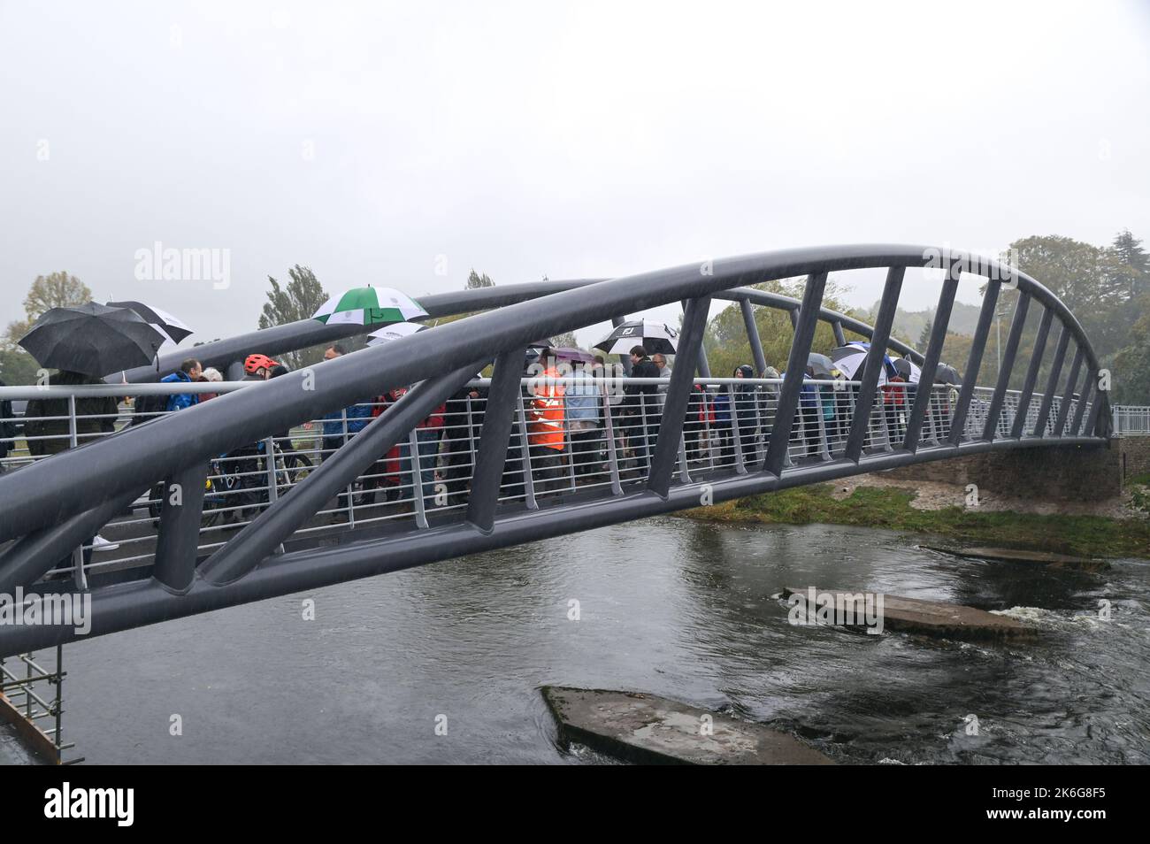 New Road, Kendal - Oktober 14. 2022 - die Gooseholme Bridge in Kendal wurde am Freitag, den 14. Oktober, vom Vorsitzenden des Cumbria County Council (CCC), Cllr Andy Connell, mit Kindern der nahegelegenen Stramongate School (alle für Fotos freigegeben) offiziell eröffnet. MP Tim Farron machte ebenfalls einen Auftritt. Die Fußgängerbrücke, die 2 Millionen Pfund kostete, ersetzte eine kleinere alte Brücke, die im Sturm Desmond beschädigt wurde, der die Stadt 2015 traf und verheerende Überschwemmungen verursachte. Die monströse Struktur wurde im Juli an ihren Platz gebracht, wobei in den letzten Monaten letzte Feinheiten vorgenommen wurden. CCC, Zusammenarbeit mit dem Auftragnehmer Story Contractin Stockfoto