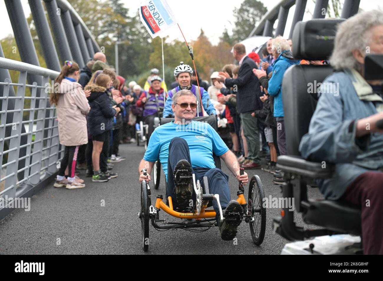 New Road, Kendal - Oktober 14. 2022 - die Gooseholme Bridge in Kendal wurde am Freitag, den 14. Oktober, vom Vorsitzenden des Cumbria County Council (CCC), Cllr Andy Connell, mit Kindern der nahegelegenen Stramongate School (alle für Fotos freigegeben) offiziell eröffnet. MP Tim Farron machte ebenfalls einen Auftritt. Die Fußgängerbrücke, die 2 Millionen Pfund kostete, ersetzte eine kleinere alte Brücke, die im Sturm Desmond beschädigt wurde, der die Stadt 2015 traf und verheerende Überschwemmungen verursachte. Die monströse Struktur wurde im Juli an ihren Platz gebracht, wobei in den letzten Monaten letzte Feinheiten vorgenommen wurden. CCC, Zusammenarbeit mit dem Auftragnehmer Story Contractin Stockfoto