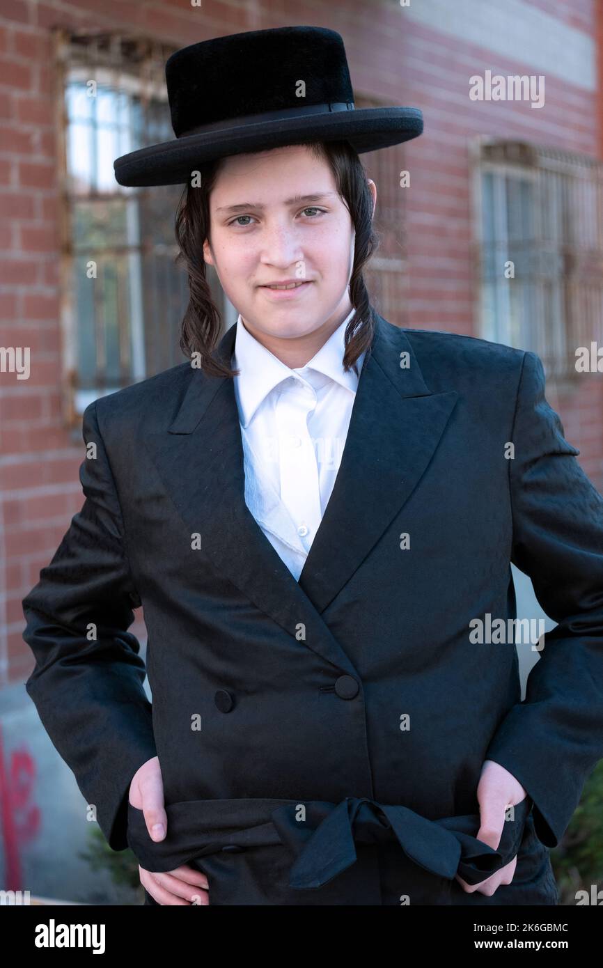 Posierte Porträt eines lächelnden orthodoxen jüdischen Teenagers. In Williamsburg, Brooklyn, New York. Stockfoto