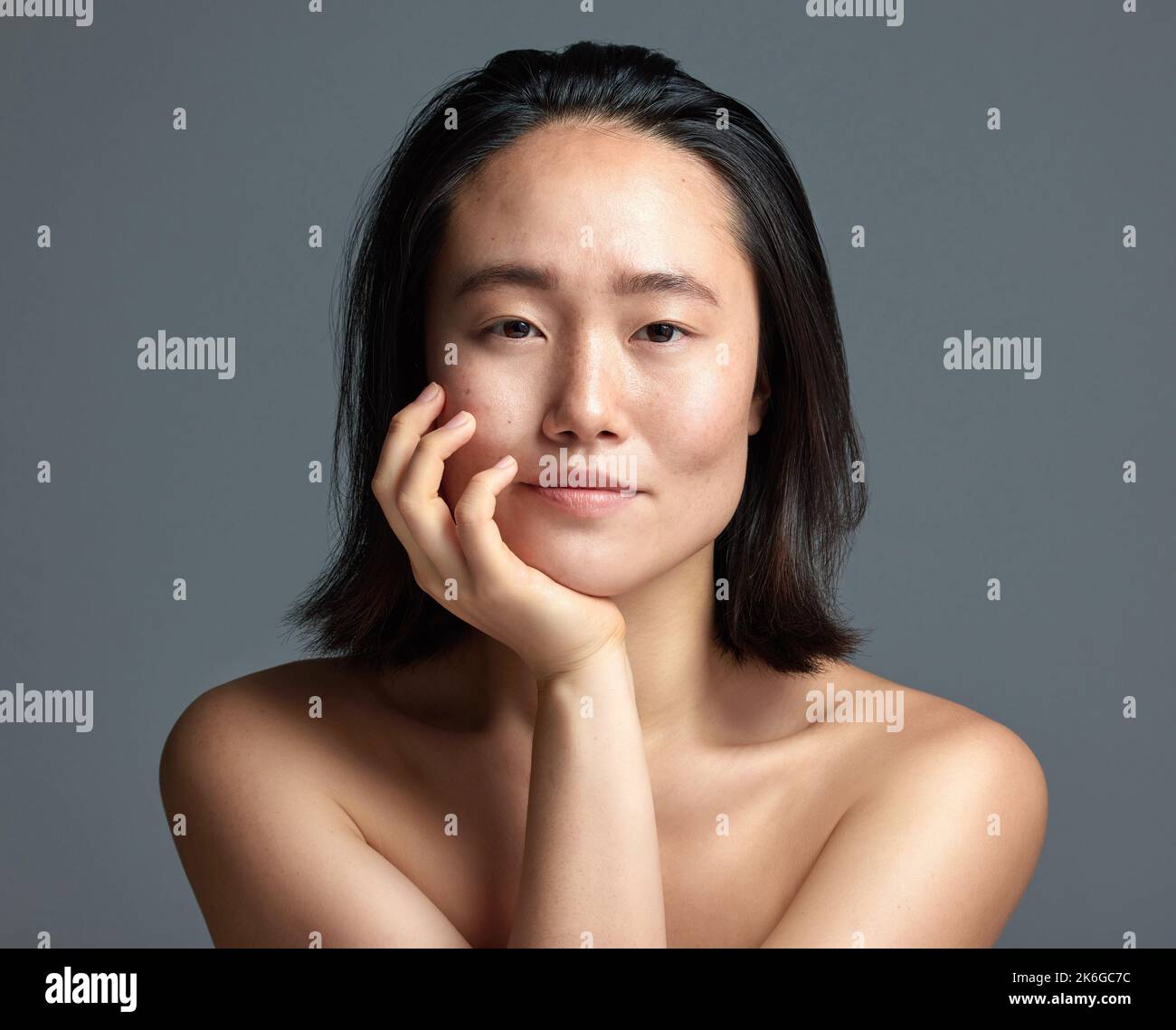 Ihre Haut sagt alles. Studioaufnahme einer schönen jungen Frau, die vor einem grauen Hintergrund posiert. Stockfoto