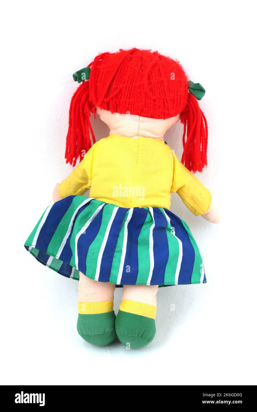 Alte weiche Rag Puppe mit grünen Schleifen in roter Wolle-Haarrückseite Stockfoto