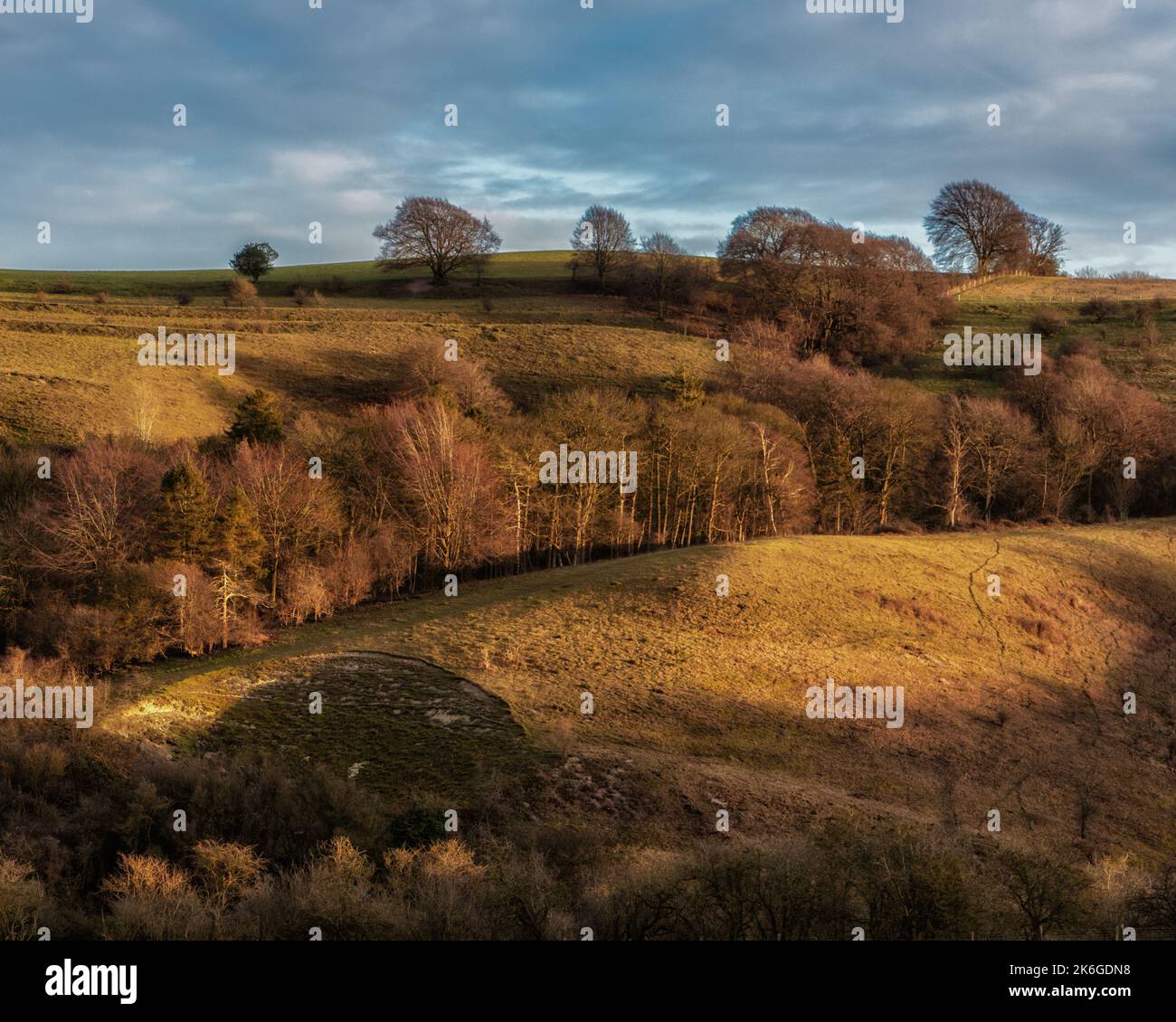 Ein hoher Winkel von gelben Pegsdon-Hügeln am Winterabend mit düsterem, bewölktem Himmel Hintergrund Stockfoto