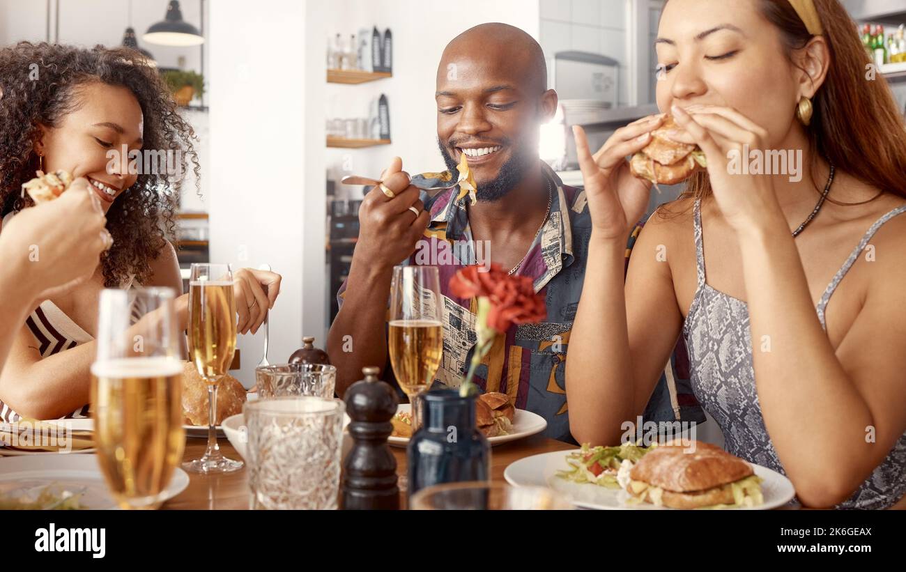Was für ein saftiger Burger. Eine Gruppe junger Freunde, die gemeinsam in einem Restaurant essen. Stockfoto
