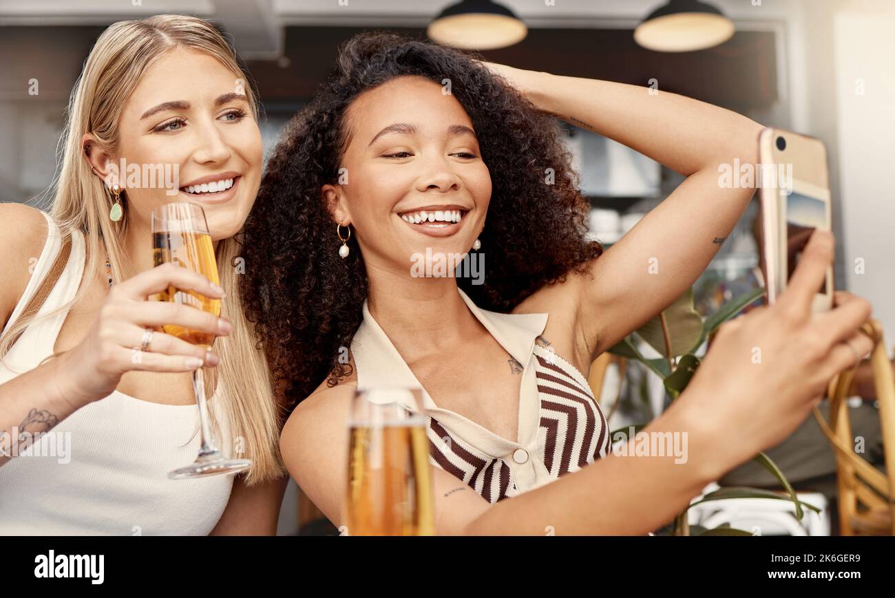 Wir nehmen uns etwas Zeit für uns. Zwei Freunde, die zusammen Selfies in einem Café machen. Stockfoto