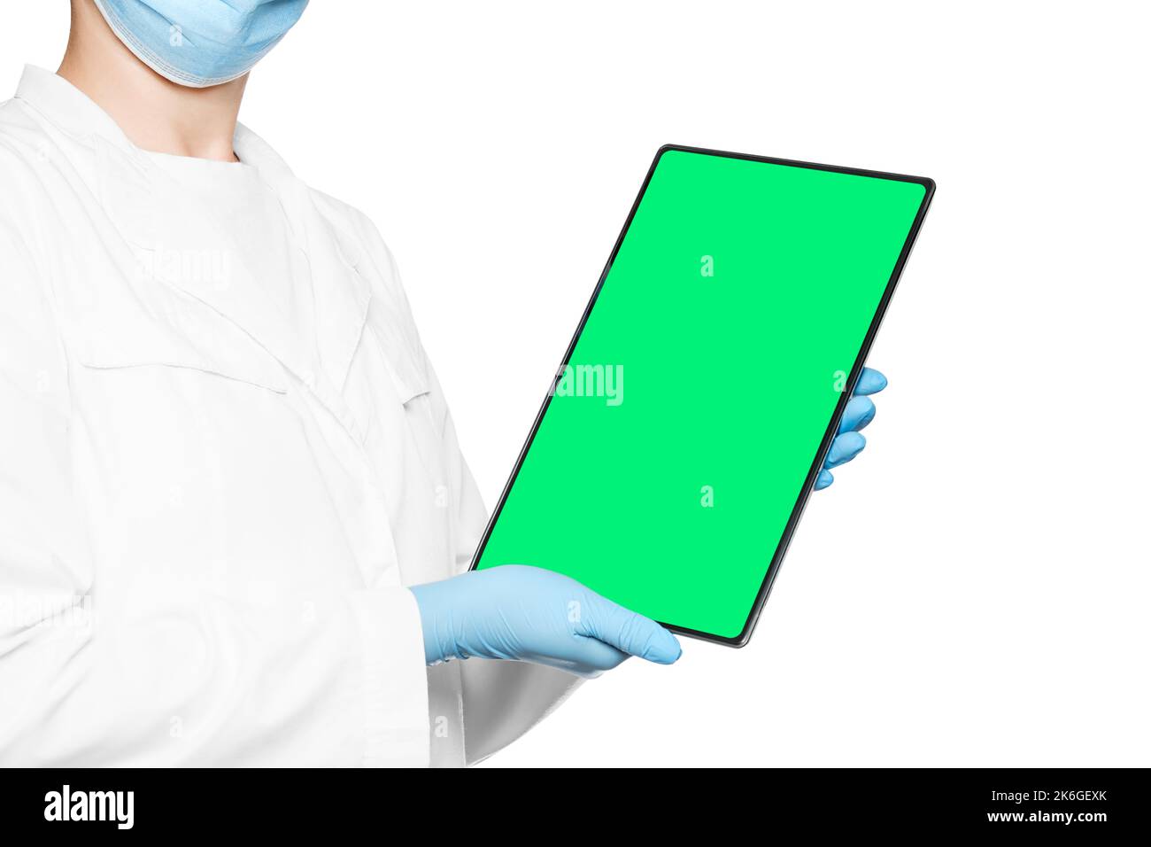 Der Arzt hält eine elektronische Tablette mit einem leeren Raum in den Händen und einem grünen Bildschirm. Stockfoto
