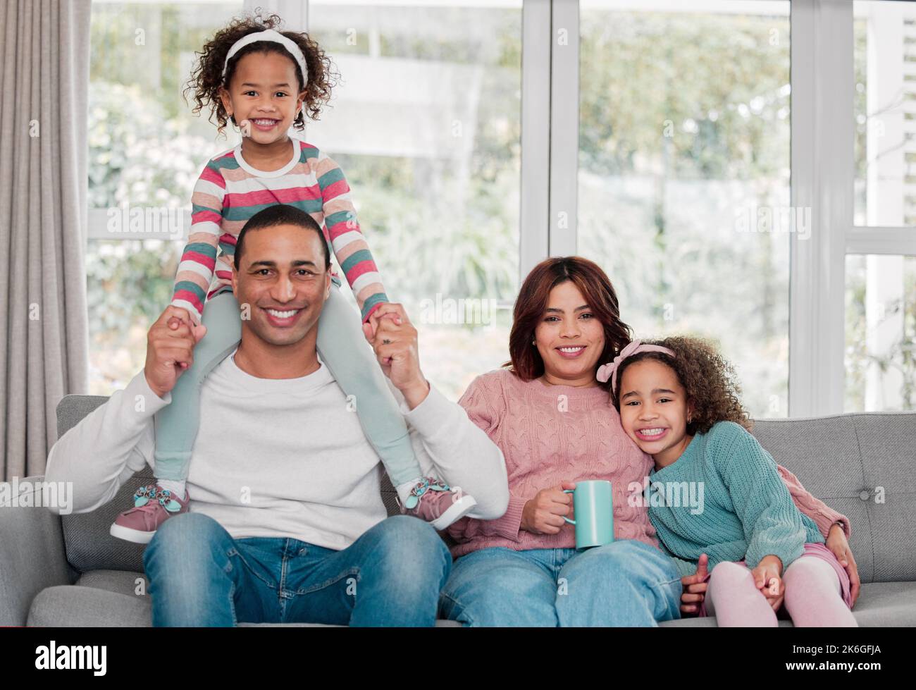 Unbeschwerte und gemütliche Tage mit den Liebsten sind die Besten. Porträt einer glücklichen Familie, die sich zu Hause verbindet. Stockfoto