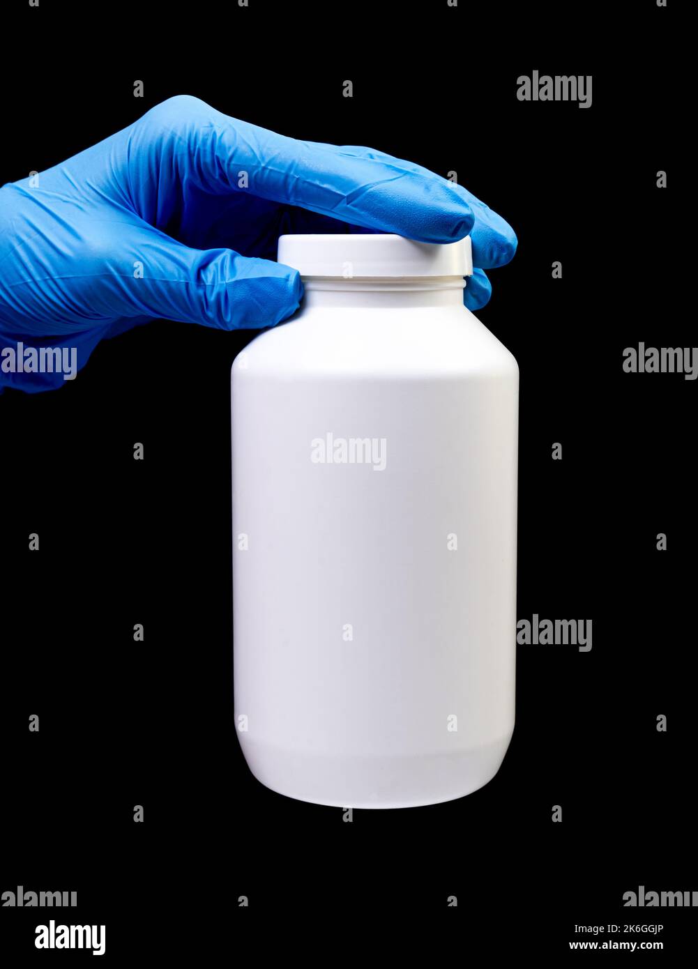 Medizinische Pillen in weißem Glas auf einem isolierten schwarzen Hintergrund mit Reflexion in der Hand natürliche Bio-Ergänzung Stockfoto