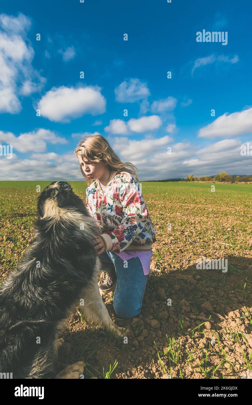 Freundschaft von Mädchen und Hund in der schönen ländlichen Landschaft in magischer Zeit Stockfoto