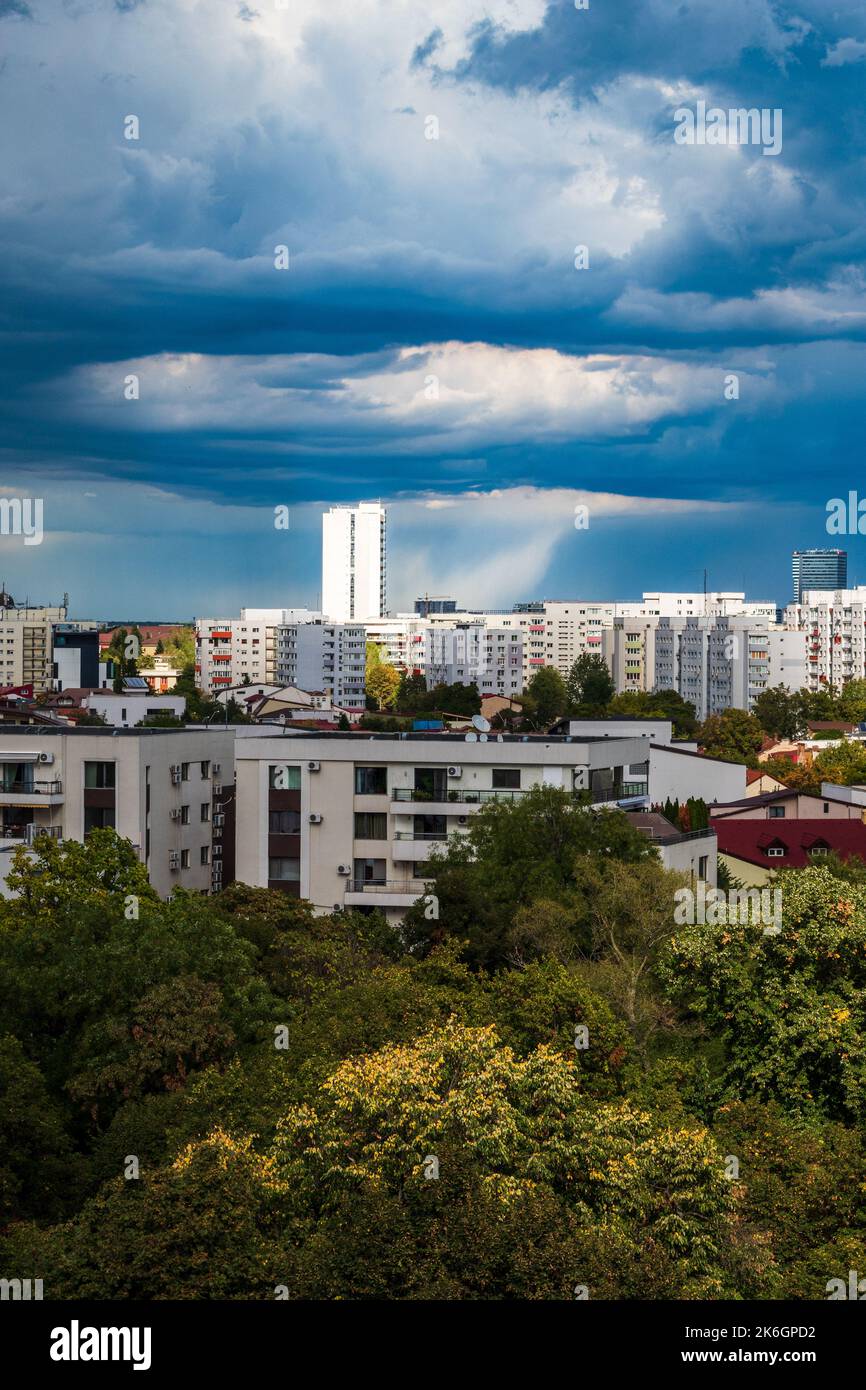 Blick vom Balkon auf den dramatischen Himmel mit Sturmwolken und Licht, das auf den Wolkenkratzer fällt. Stockfoto