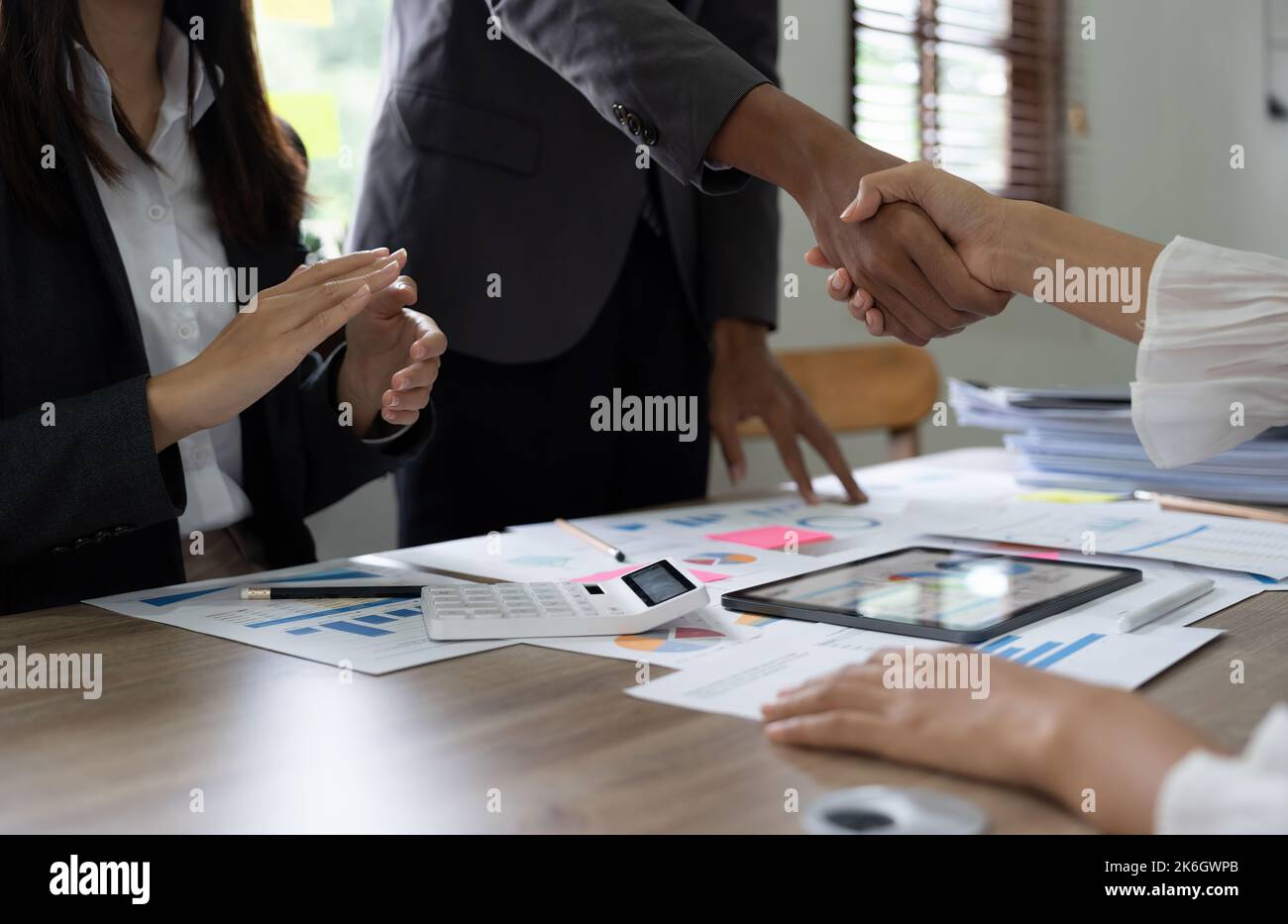Gruppe Geschäftsleute Handshake am Besprechungstisch im Büro zusammen mit selbstbewussten Schuss aus der Draufsicht . Junge Geschäftsmann und Geschäftsfrau Arbeiter Stockfoto