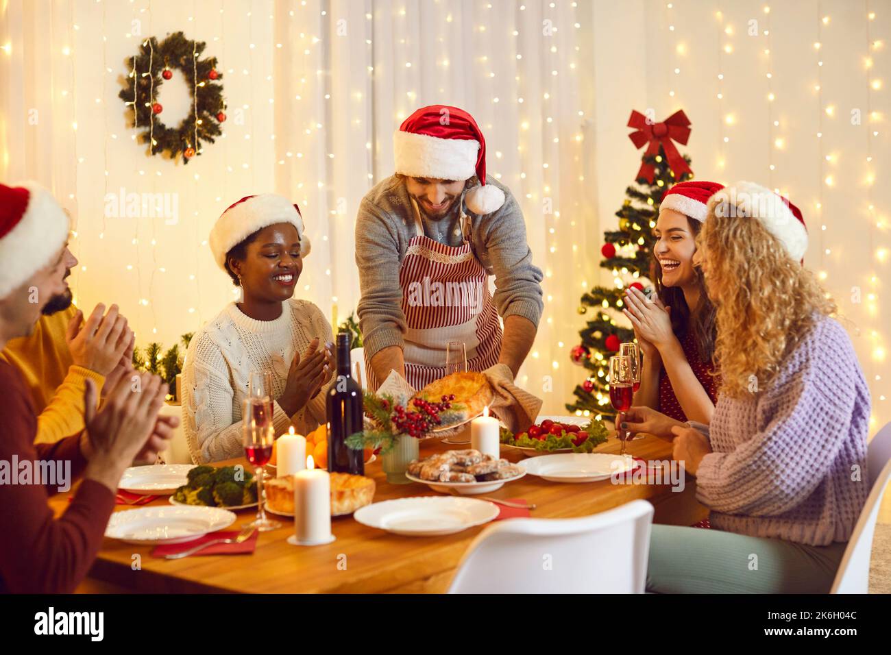 Fröhliche internationale Freunde essen zusammen Weihnachten Stockfoto