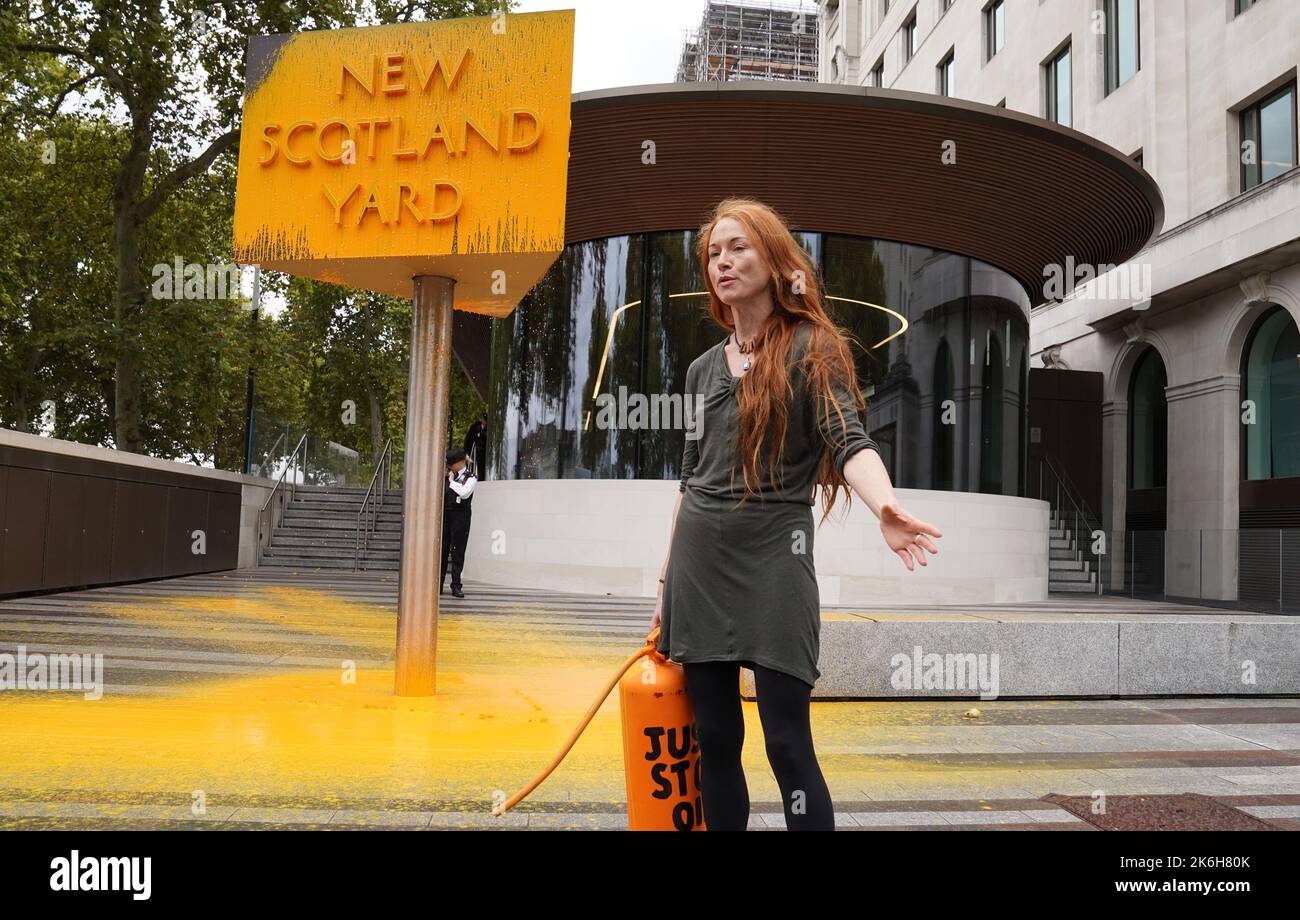 Ein „Just Stop Oil“-Spray malt ein Schild vor dem New Scotland Yard in London. Bilddatum: Freitag, 14. Oktober 2022. Stockfoto