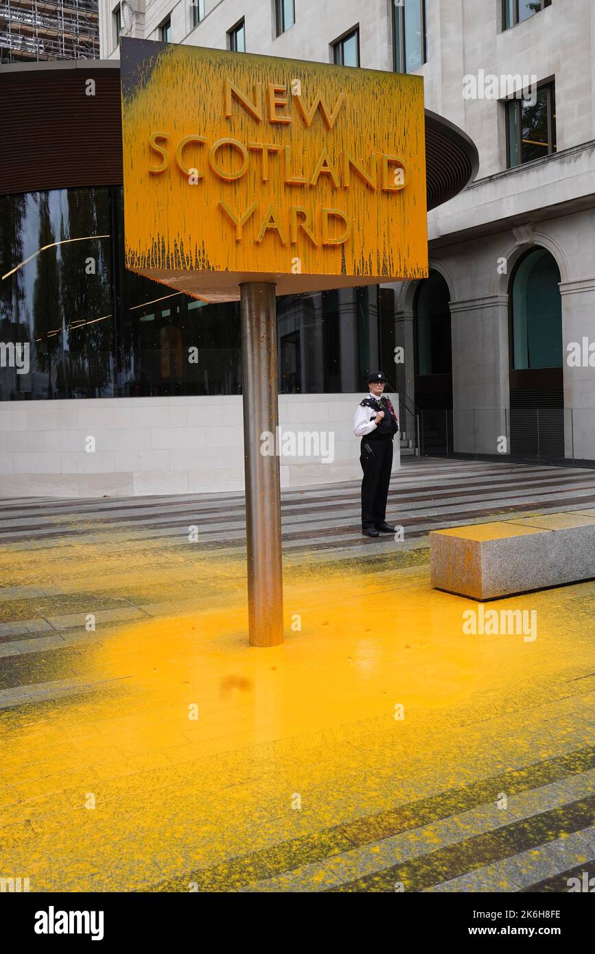 Ein „Just Stop Oil“-Proesterspray malte ein Schild vor dem New Scotland Yard in London. Bilddatum: Freitag, 14. Oktober 2022. Stockfoto