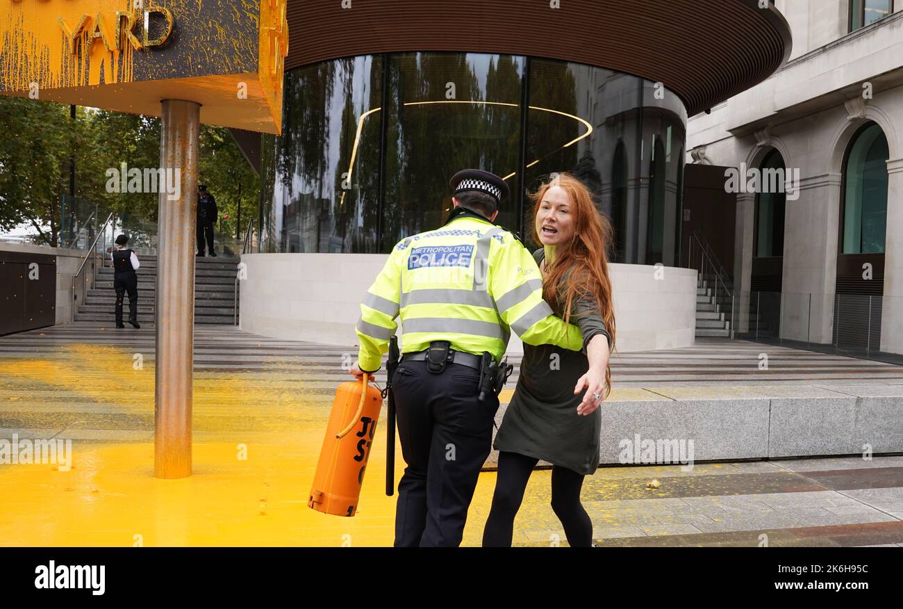 Polizisten verhaften einen Protestierenden von Just Stop Oil, nachdem sie vor dem New Scotland Yard in London ein Schild mit Sprühnebel besprüht hatte. Bilddatum: Freitag, 14. Oktober 2022. Stockfoto