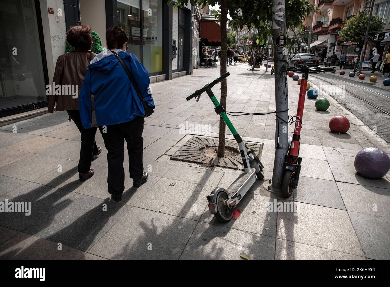 Istanbul, Türkei. 14. Oktober 2022. Fußgänger laufen an Motorroller vorbei, die entlang der Straßen in Istanbul Kadikoy geparkt sind. Elektroroller, die mit Handy-Anwendungen verwendet werden, sind in den letzten Jahren sehr beliebt geworden, um in der Stadt zu pendeln, aber sie werden oft unregelmäßig an den Straßenrändern und auf den Straßen von Istanbul geparkt, was Fußgängern das Gehen erschwert. Kredit: SOPA Images Limited/Alamy Live Nachrichten Stockfoto