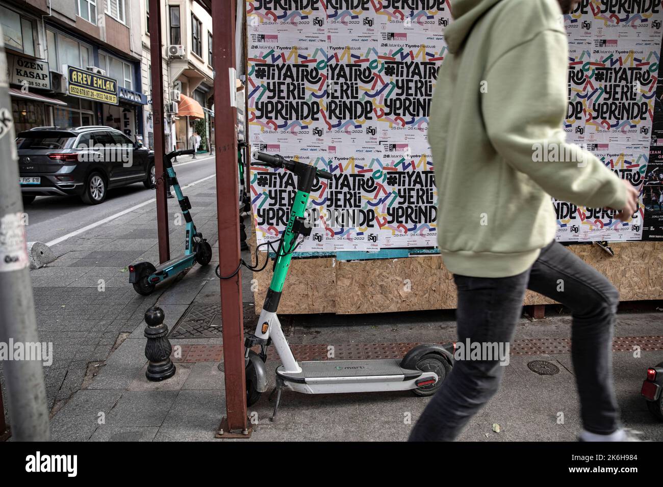 Istanbul, Türkei. 14. Oktober 2022. Ein Fußgänger läuft am Roller vorbei, der entlang der Straßen in Istanbul Kadikoy geparkt ist. Elektroroller, die mit Handy-Anwendungen verwendet werden, sind in den letzten Jahren sehr beliebt geworden, um in der Stadt zu pendeln, aber sie werden oft unregelmäßig an den Straßenrändern und auf den Straßen von Istanbul geparkt, was Fußgängern das Gehen erschwert. Kredit: SOPA Images Limited/Alamy Live Nachrichten Stockfoto