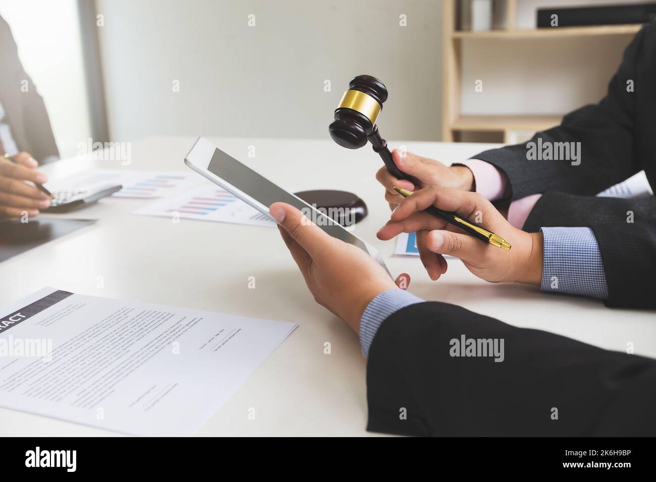 Rechtsanwälte oder Rechtsberater verwenden Tablet, um rechtliche Begriffe zu Handelsverträgen zu finden. Handelsrecht und Geschäftskooperation Konzept. Stockfoto