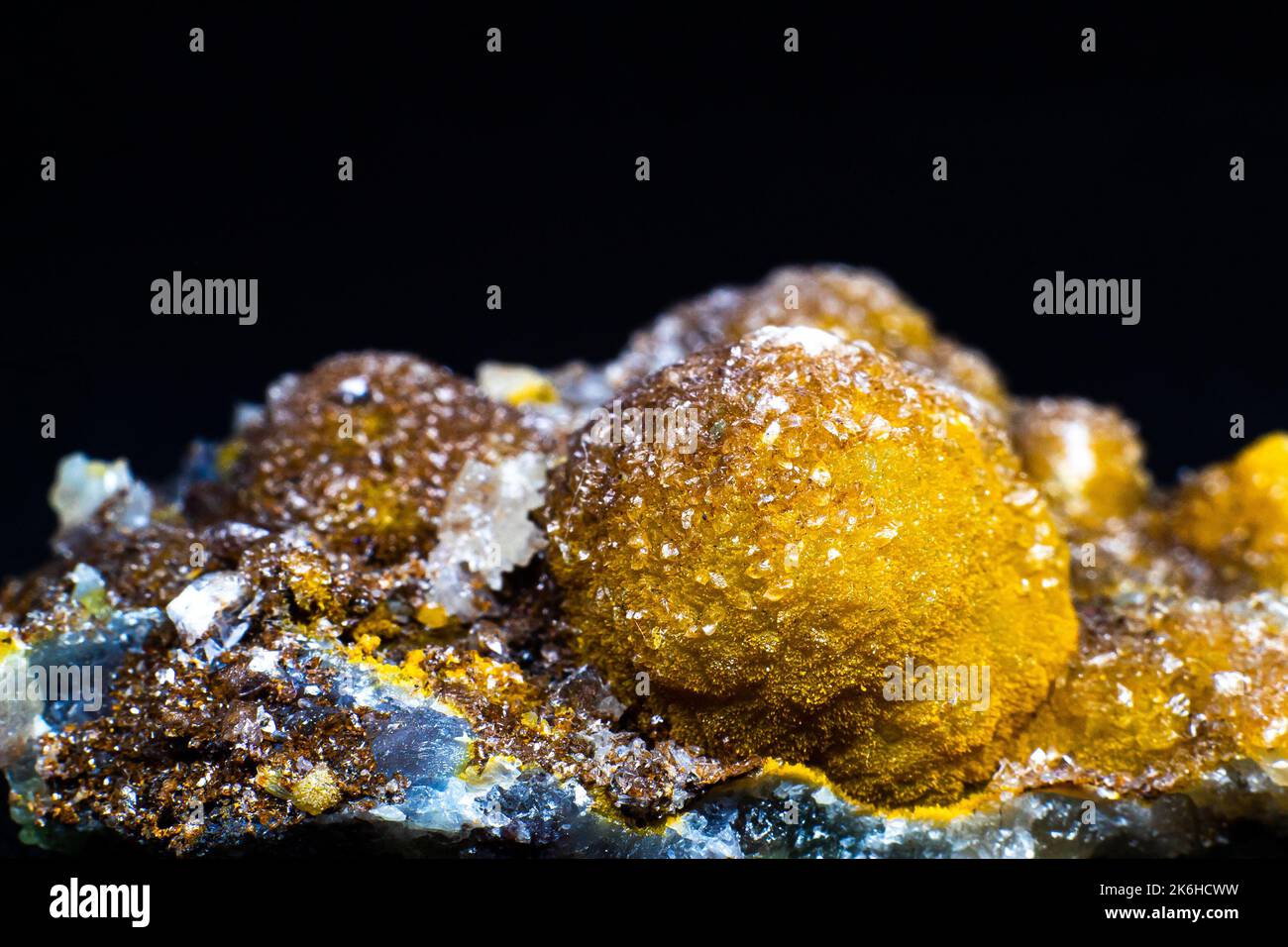 Gelbes Schmiedesoniten Kristall isoliert auf schwarzer Oberfläche Makro mit viel Detail. Selektiver Fokus Stockfoto