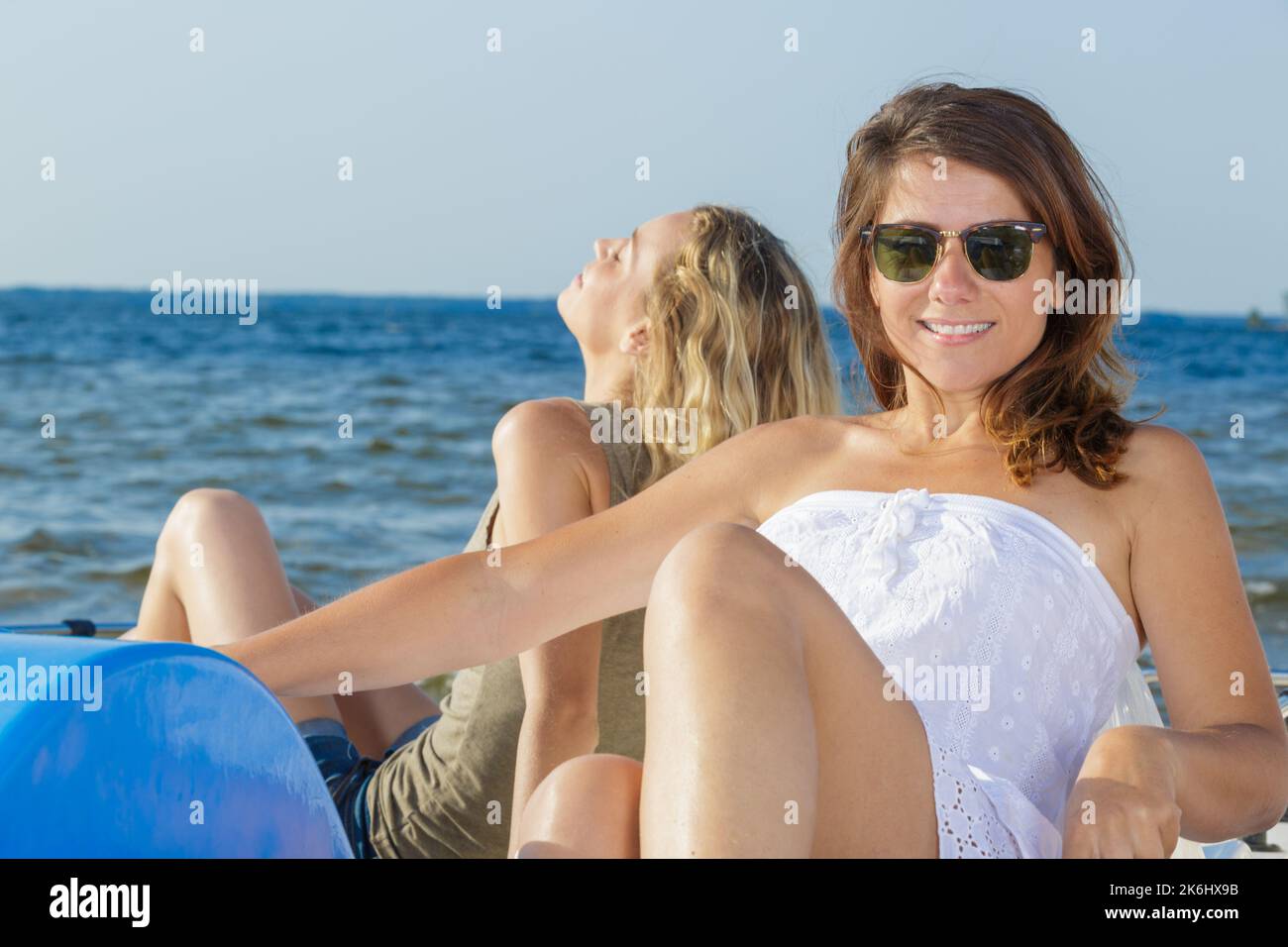 Zwei wunderschöne Frauen, die sich auf einem Pedalo in der Sonne sonnen Stockfoto