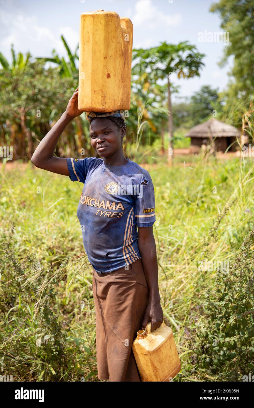 Frauen gehen lange Wege, um Wasser nach Hause zu bringen im Distrikt Abim, Uganda, Ostafrika. Stockfoto