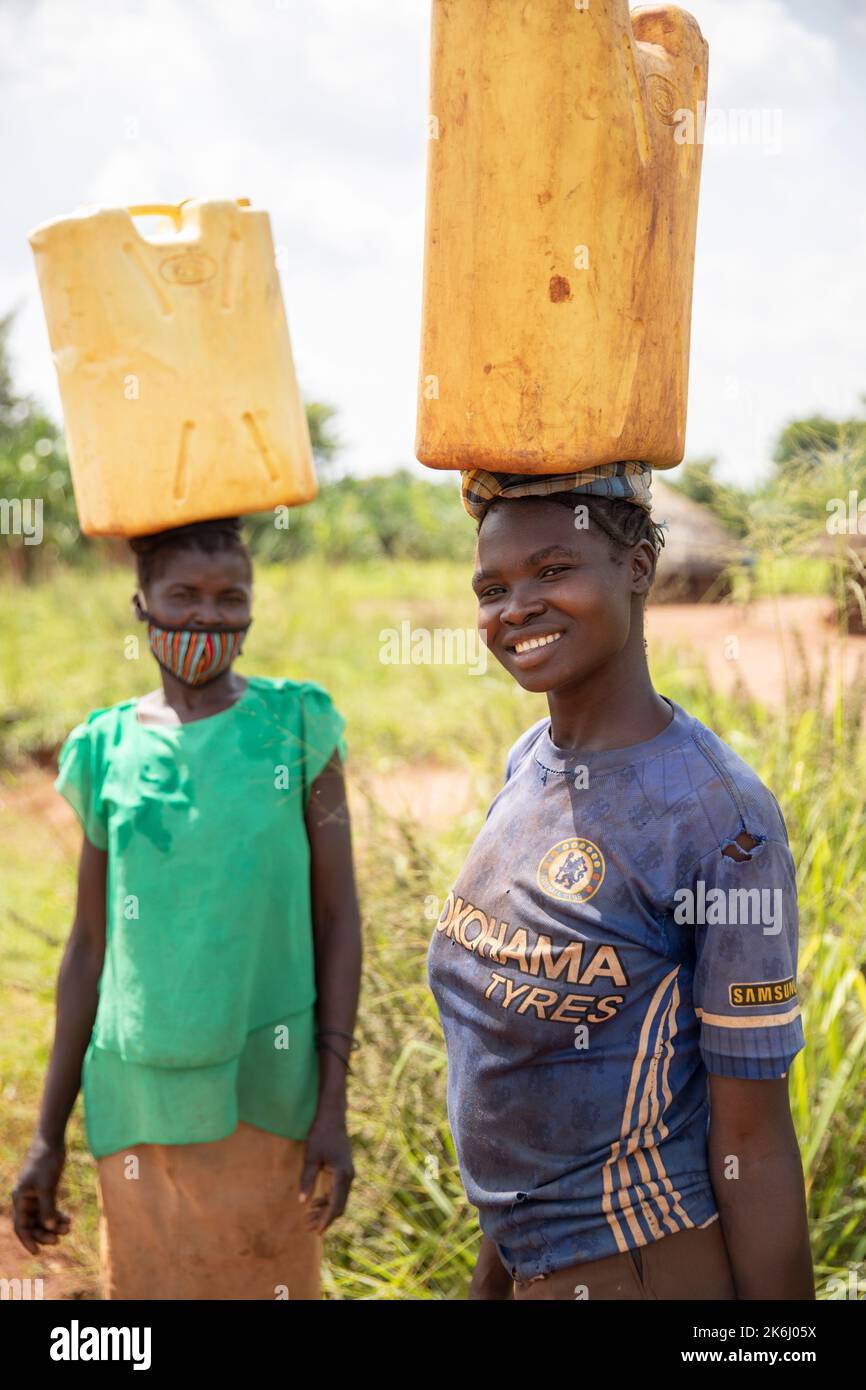 Frauen gehen lange Wege, um Wasser nach Hause zu bringen im Distrikt Abim, Uganda, Ostafrika. Stockfoto