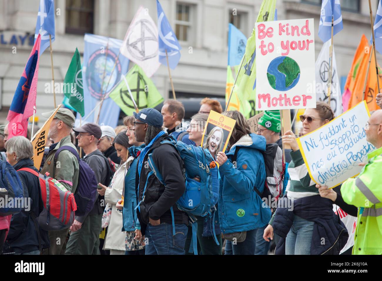 London, Großbritannien, 14. Oktober 2022: Extinction Rebellion marschiert Whitehall hinunter zur Downing Street, wo sie symbolisch Stromrechnungen verbrannten. Der Slogan des Protestes lautete: „Wir können uns das nicht leisten“, und bezog sich sowohl auf die Energiekosten in der Lebenshaltungskrise als auch auf die Klimakrise, die durch die Verbrennung fossiler Brennstoffe verursacht wurde. Auf den Postern wurde Liz Truss als Mitarbeiterin des Monats gezeigt, die ihre Verbindungen zur fossilen Energiewirtschaft hervorhob. Anna Watson/Alamy Live News Stockfoto