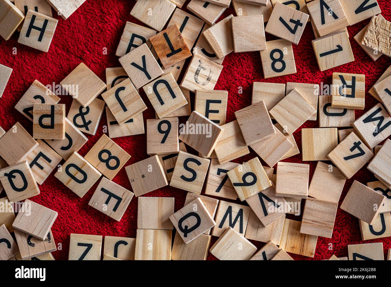 Schwarze Buchstaben auf Holz gelegt. Kleine Teile des Alphabets. Stockfoto