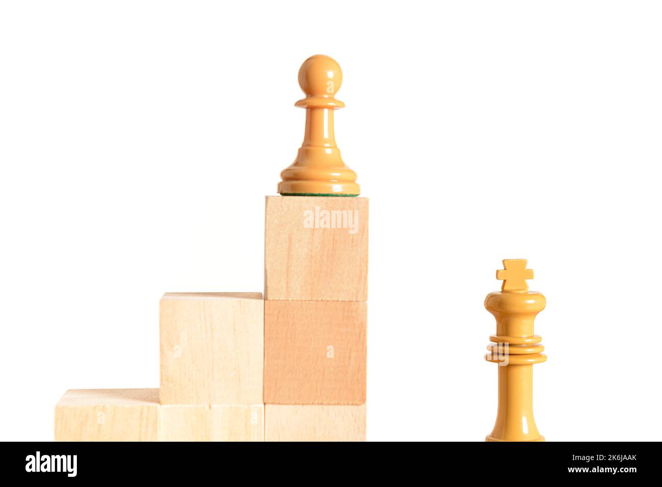 Weiße Schachfigur auf einem Holzblock, der eine Treppe bildet, neben und über dem weißen König. Konzept der Selbstverbesserung. Weißer Hintergrund und Platz für Text Stockfoto