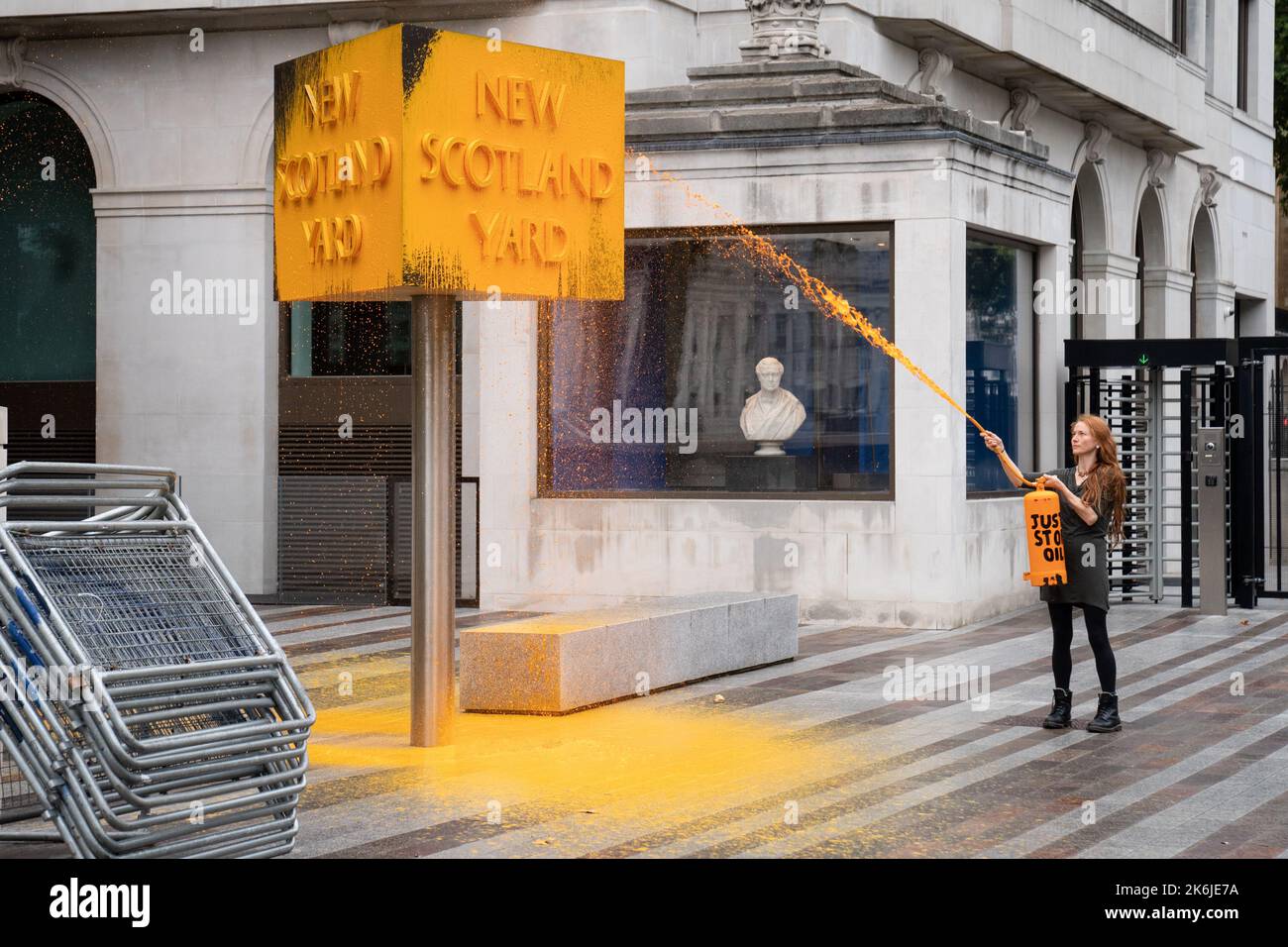 Ein „Just Stop Oil“-Spray malt ein Schild vor dem New Scotland Yard in London. Bilddatum: Freitag, 14. Oktober 2022. Stockfoto