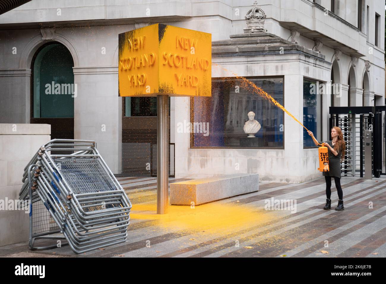Ein „Just Stop Oil“-Spray malt ein Schild vor dem New Scotland Yard in London. Bilddatum: Freitag, 14. Oktober 2022. Stockfoto