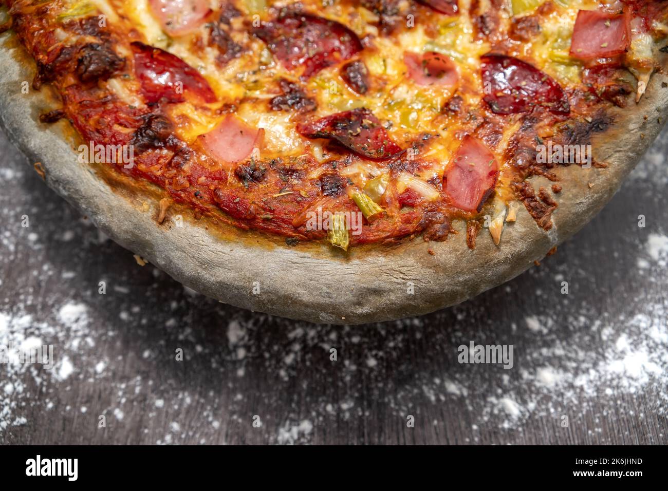 Nahaufnahme von frisch gebackener innovativer Pizza mit grauem Teig. Gesunde hausgemachte italienische Küche. Stockfoto