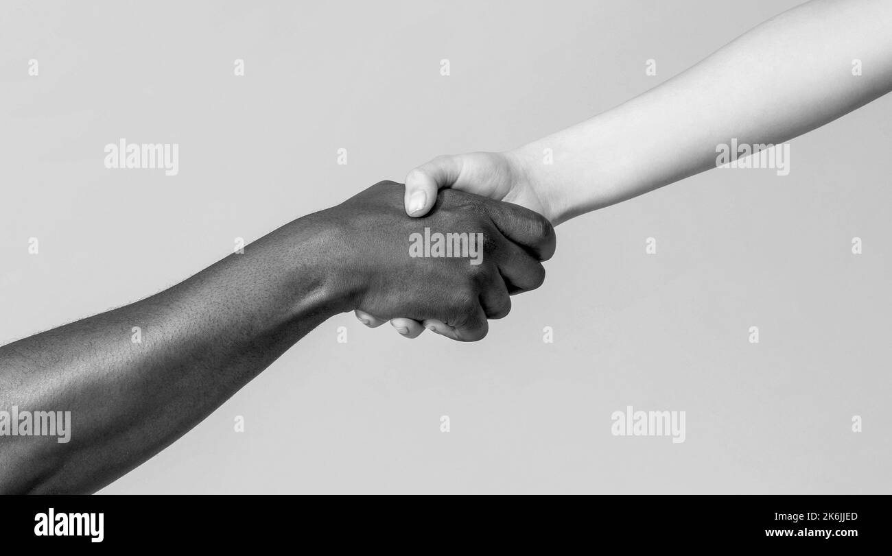 Frau und afrikanische Frau Hand. Helfende Hand, Rettung, multiathische Menschen. Helfende Hände, Rettungsgeste. Schwarz und Weiß Stockfoto