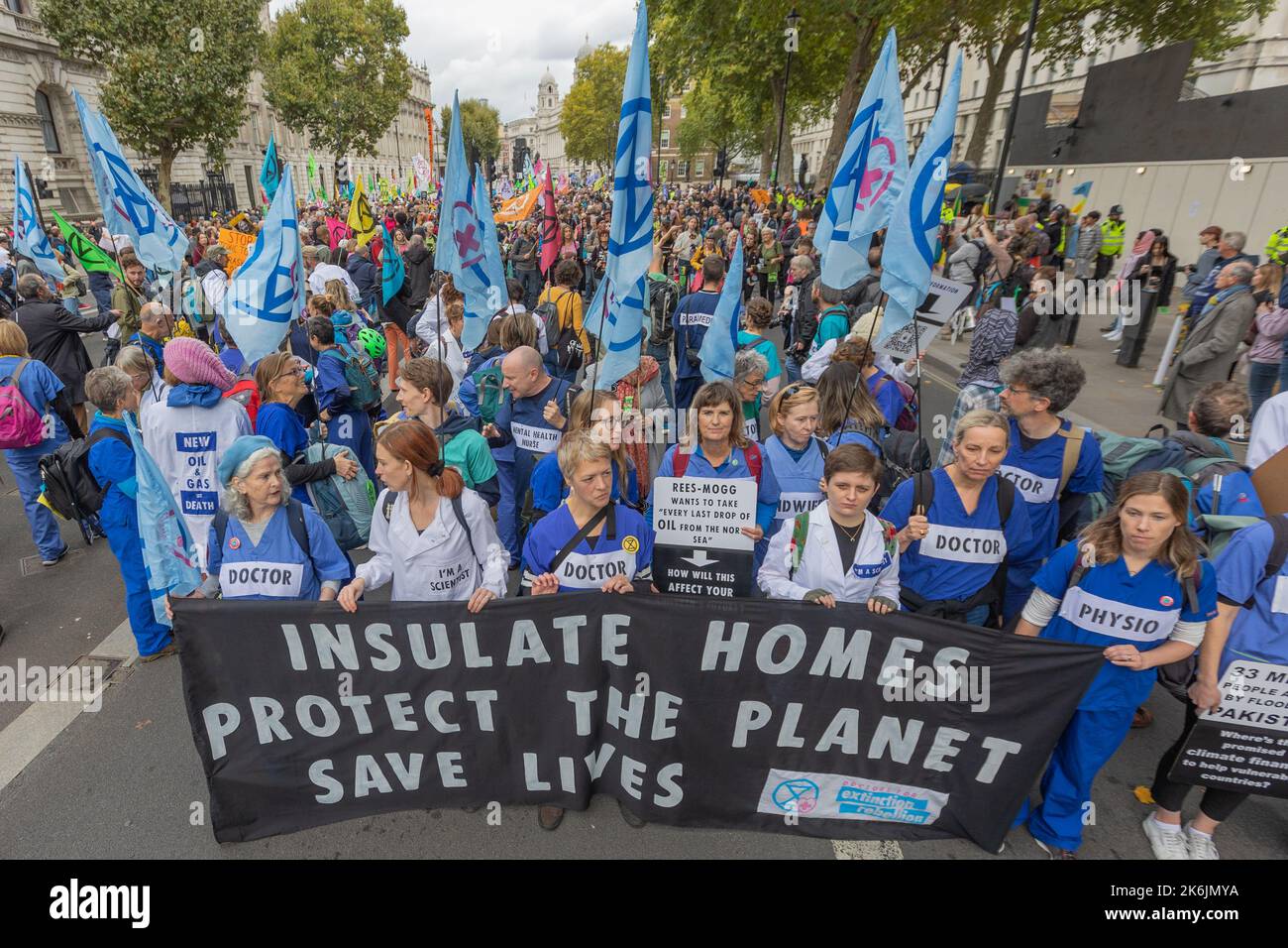London, Großbritannien. Oktober 2022. Ärzte, Krankenschwestern und Physiotherapeuten protestieren im Zentrum Londons, um sich für die Isolierung von Häusern als Maßnahme für die öffentliche Gesundheit und das Klima einzusetzen. Auf dem Banner steht: Häuser isolieren, den Planeten beschützen, Leben retten. Die Teilnehmer tragen NHS-Uniformen und Schilder, die ihre Rollen kennzeichnen. Demonstranten der Extinction Rebellion treffen sich am Trafalgar Square, bevor sie zur Downing Street marschieren, wo sie bis 18:00 Uhr bleiben wollen. Der Protest hat das Thema, dass wir uns das nicht mehr leisten können. Penelope Barritt/Alamy Live News Stockfoto