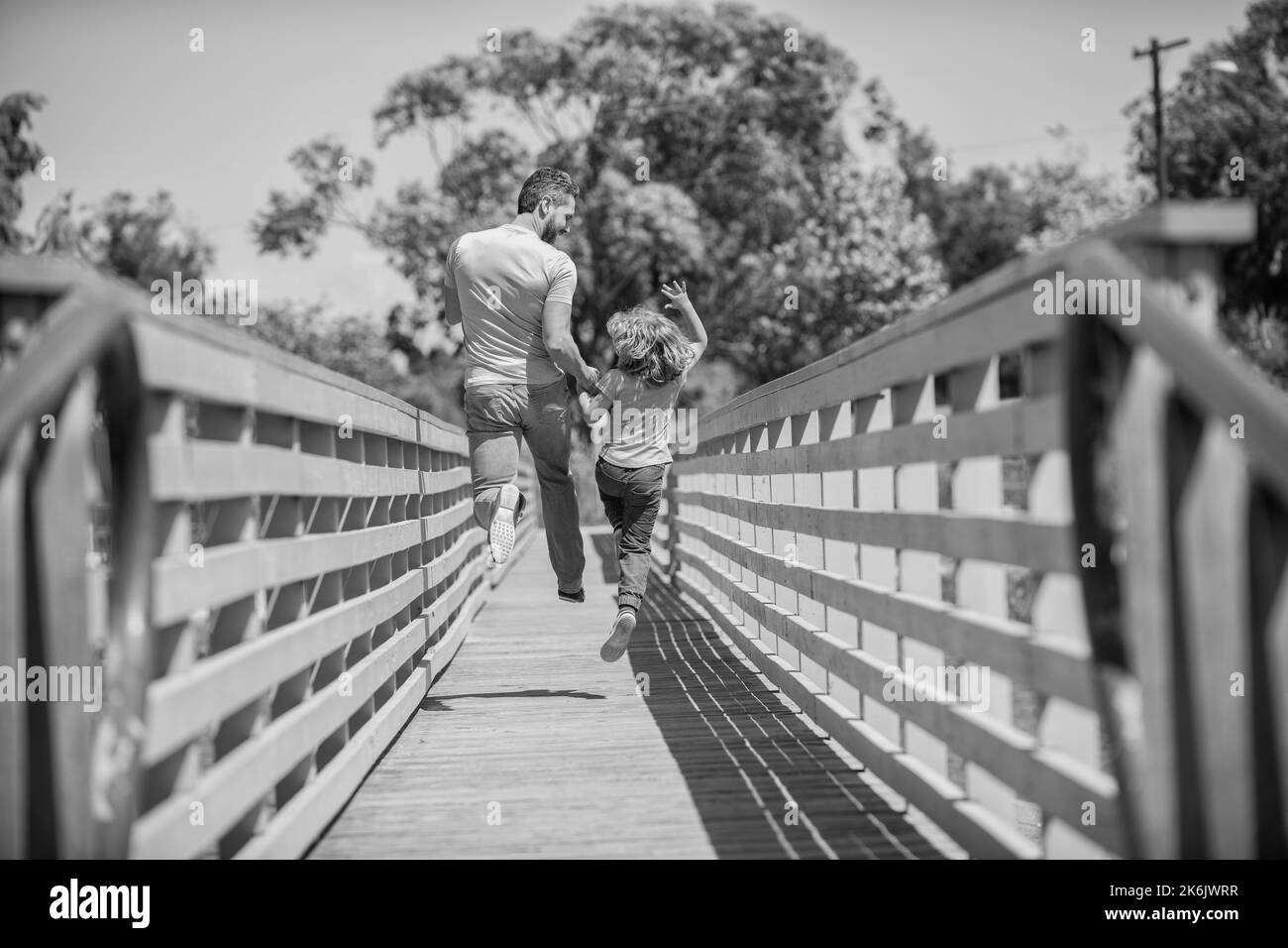 Glücklicher Vater, der Spaß hat, mit seinem Sohn draußen zu laufen, Rückansicht, Vaterschaft Stockfoto