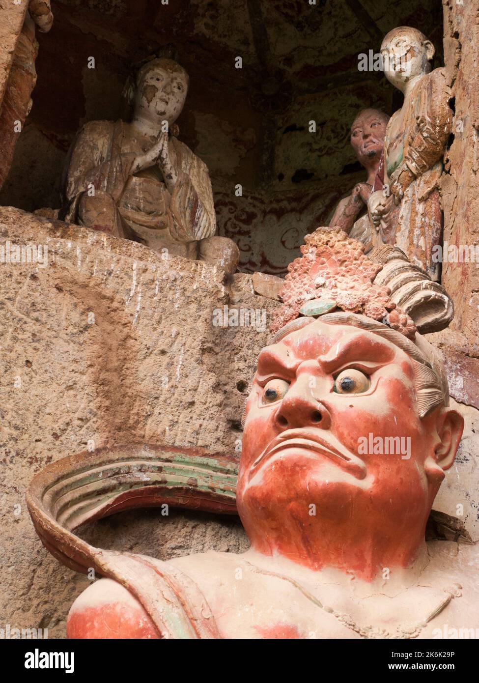 Figuren in der Höhle 004, die während der nördlichen Zhou-Zeit in den Jahren 557 bis 581 errichtet wurde. Treppen und Gehwege, die an der gemeinsamen Felswand befestigt sind, ermöglichen es den Besuchern, die alten Lehmstatuen von Buddha und buddhistischen Gottheiten zu sehen, die an der Steinoberfläche der Felswand angebracht und geschnitzt sind. Die Maijishan-Grotten, früher als Maichishan romanisiert, sind eine Reihe von 194 Höhlen, die in die Seite des Hügels von Majishan, Tianshui, Provinz Gansu, geschnitten wurden. Nordwest-China. (126) Stockfoto