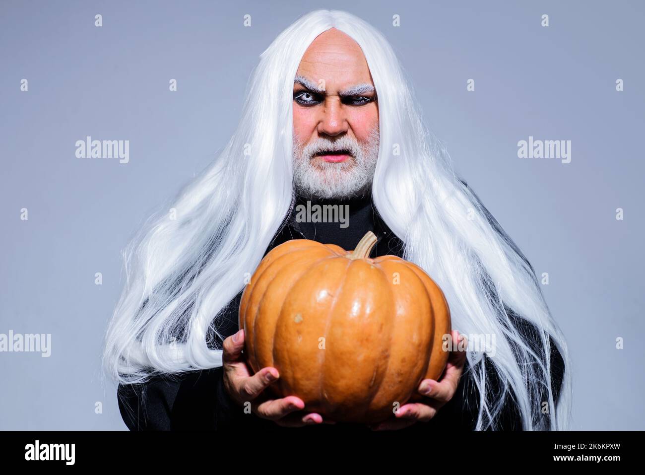 Halloween Teufelsmann mit Kürbis. Bärtiger Rüde im Hexer-Kostüm bereit zur Party. Stockfoto