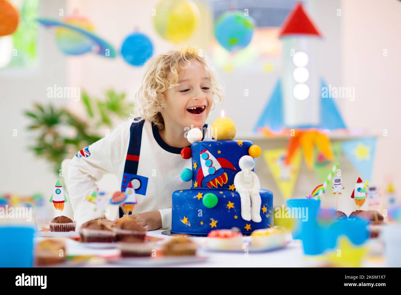 Kinder Raum Thema Geburtstagsfeier mit Kuchen und Cupcakes. Rakete, Sonnensystem Planet und Raumschiff Dekoration für Kinder-Event. Stockfoto