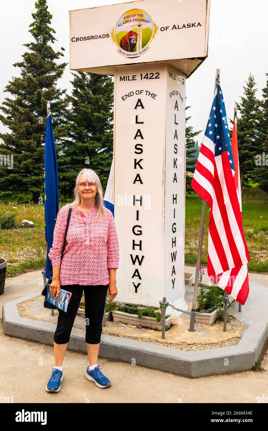 Senior Woman; Beschilderung am Endpunkt des Alaska Highway; Delta Junction; Alaska; USA Stockfoto