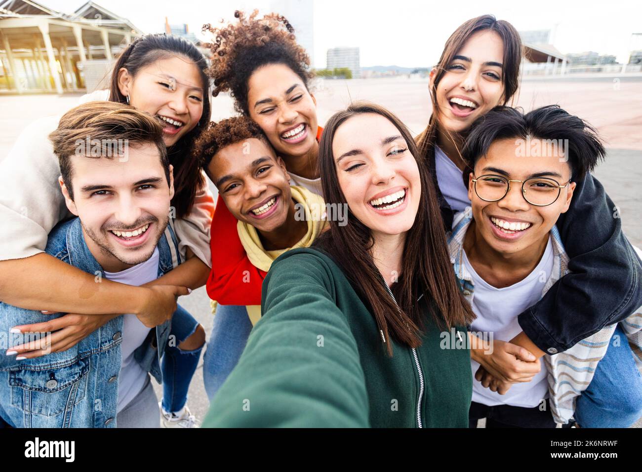 Lustige junge Gruppe multiethnischer Freunde, die sich im Freien gemeinsam porträtieren Stockfoto