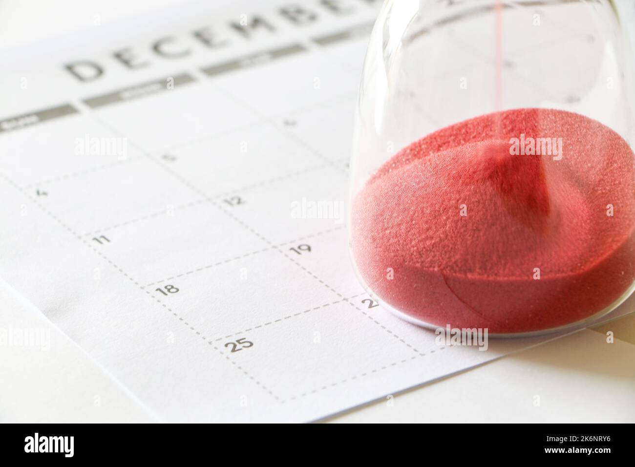 Sanduhr am Dezember-Kalender zum 25.. Dezember, Countdown bis Weihnachten, läuft roter Sand durch Sanduhr-Birnen, die den Durchgang von tim messen Stockfoto
