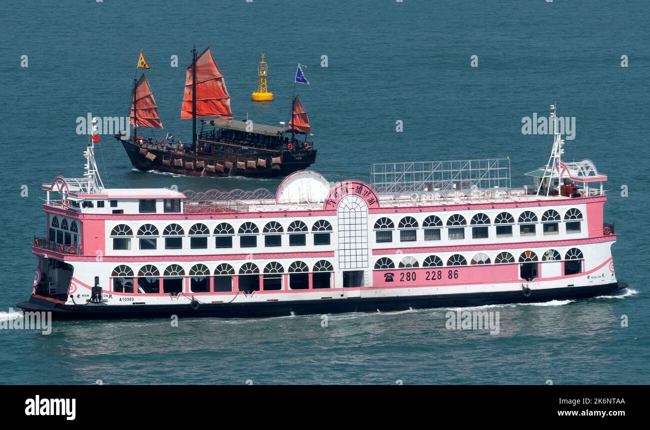 Traditionelle chinesische Dschunke und Touristenfähre, Victoria Hafen, Hongkong, China. Stockfoto