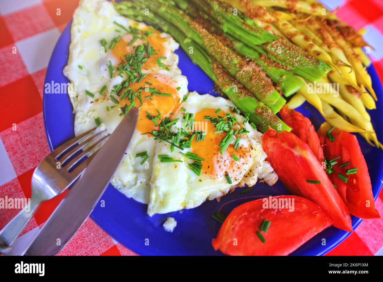 Köstliches hausgemachtes Abendessen - Ei mit Bohnen und Spargel und Tomaten Stockfoto