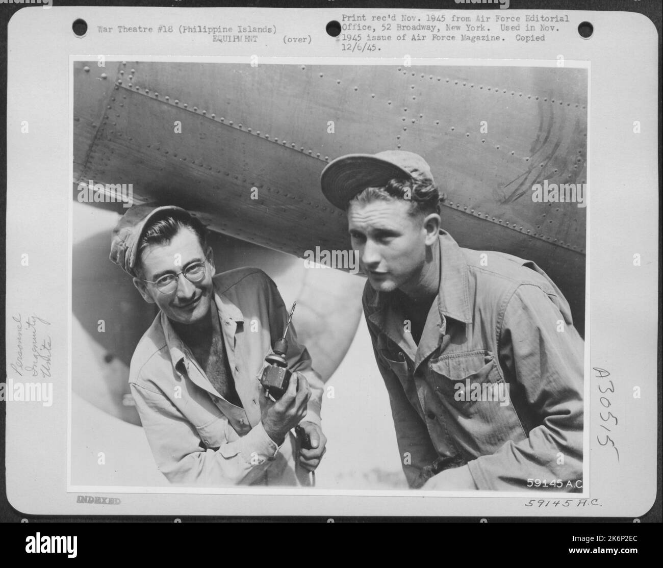 Als ein Bohrer, der hohe Drehmomentausbeute bei langsamer Geschwindigkeit kombiniert und dabei den 24-Volt-Strom eines Flugzeugs nutzt, auf einer Basis der Bombardierungsgruppe von 5. auf den Philippinen, S/Sgt, benötigt wurde. Aimsey Reed, Clarkston, Wash., (links) und Sgt. Charles Mosley, Princeton, Ky. Stockfoto